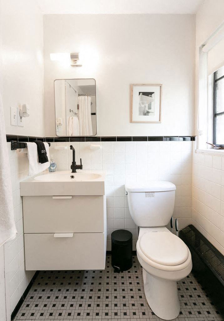 A white toilet sits in a bathroom next to a white sink.