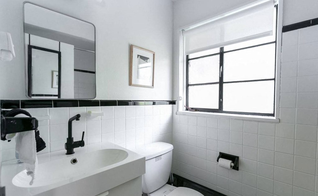 A white sink in a bathroom with a window.