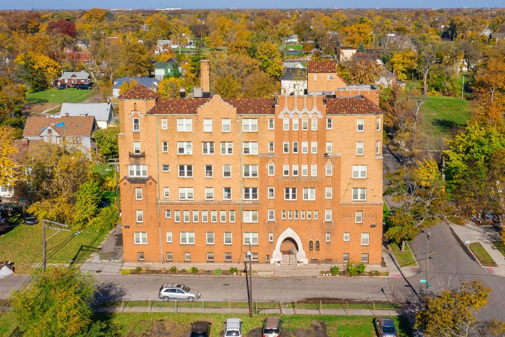 A large red brick building with a green lawn in front.