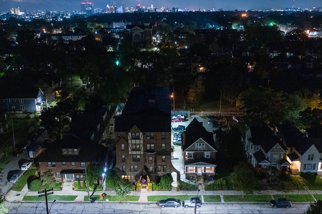 A nighttime view of a residential neighborhood with houses and streetlights.