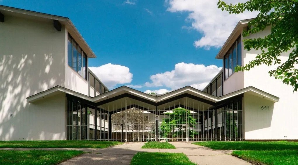A modern house with a white exterior and a black gate.