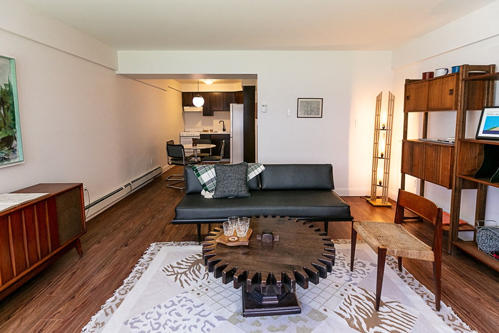 A living room with a black couch and a coffee table in the center.