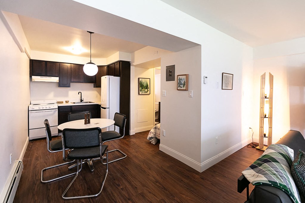 A kitchen with a table and chairs.