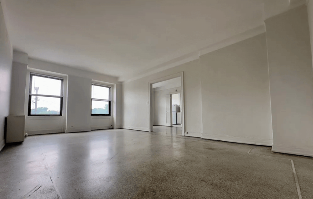 Empty room with white walls and concrete floor.