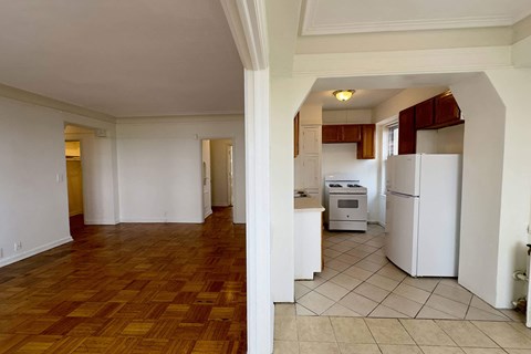 A kitchen with white appliances and wooden floors.