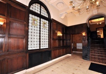A large room with wooden paneling and a stained glass window.