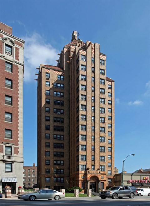A tall brick building with a red brick building to the left of it.