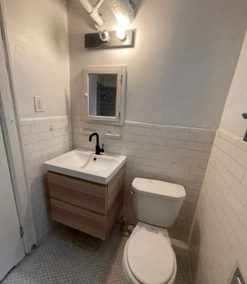 A white toilet sits next to a sink in a small bathroom.