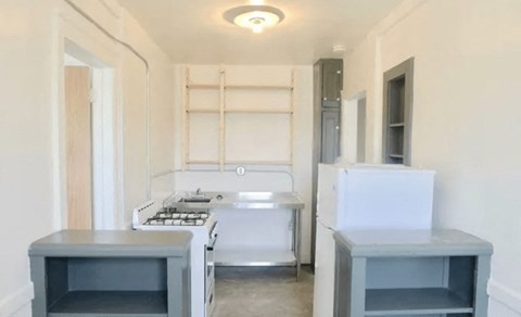 A kitchen with a white stove top oven and a white fridge.