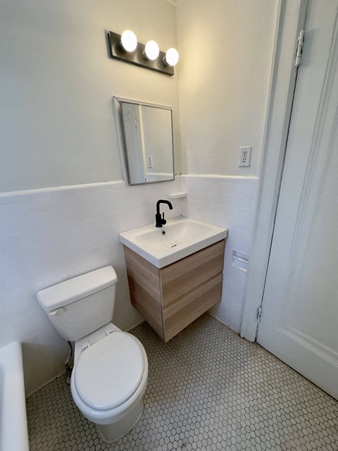 A white toilet sits next to a sink in a bathroom.