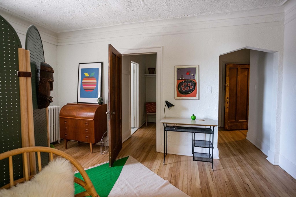 A room with a green rug and a chair.