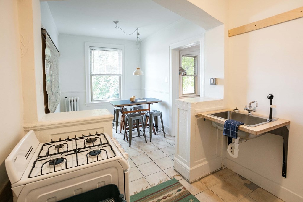 A kitchen with a white stove and a sink.