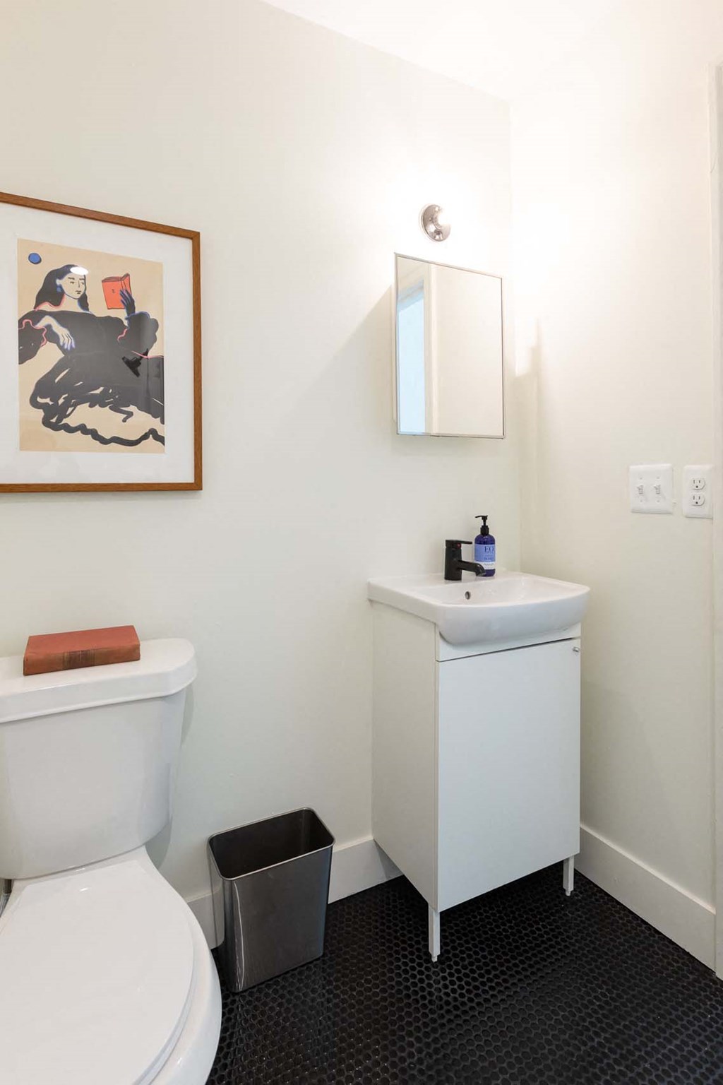 A white toilet sits next to a white sink in a bathroom.