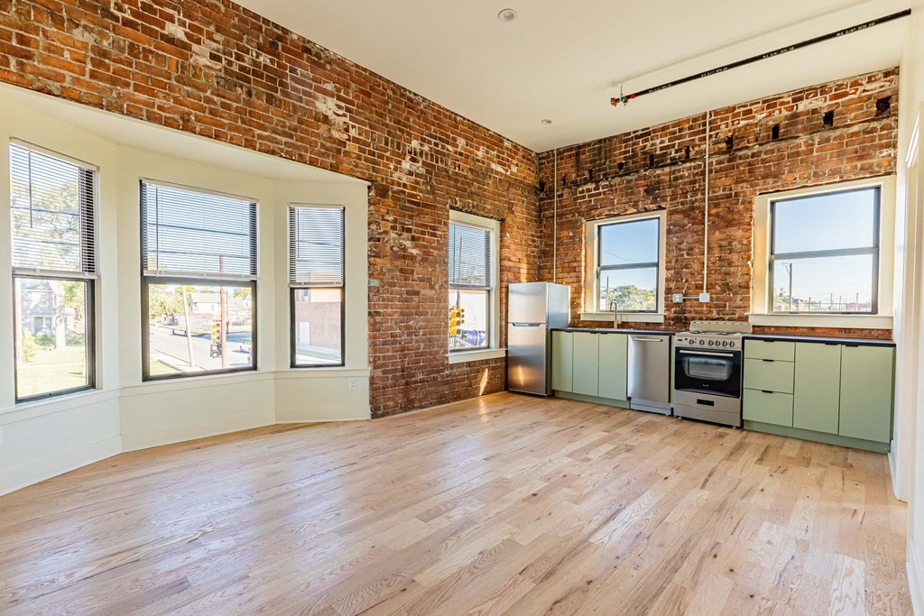 A room with a brick wall and wooden floors.