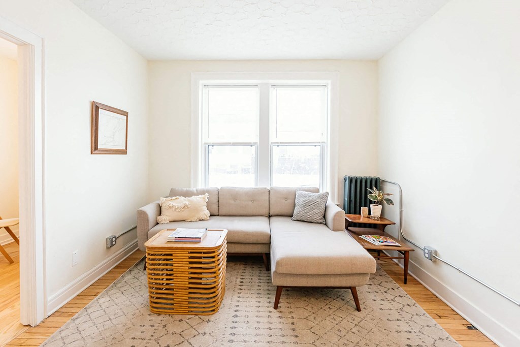 A living room with a couch, a table, and a window.