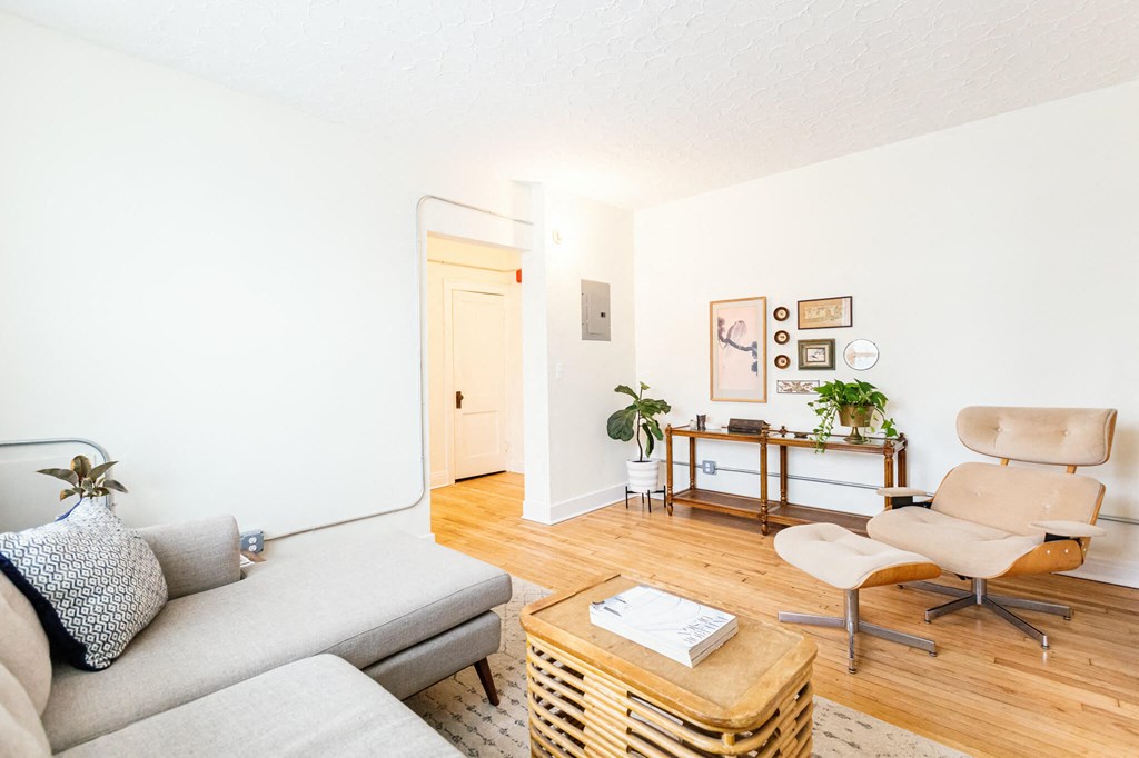 A living room with a grey couch, a wooden coffee table, and a beige chair.