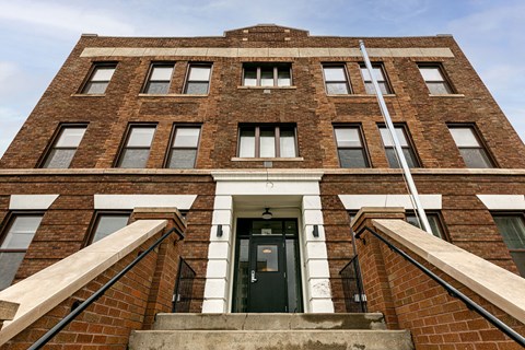 A red brick building with a black door and windows.