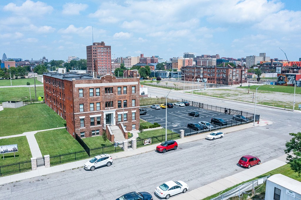 A parking lot with cars and a red car in the foreground.