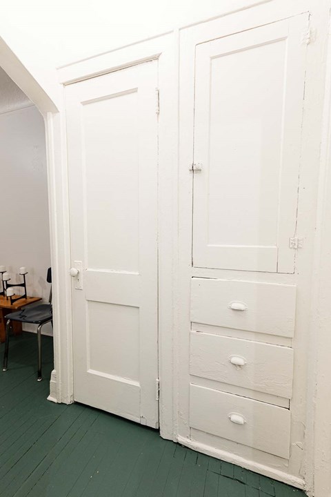 A white door with a drawer underneath it.