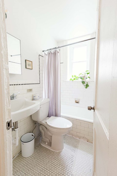 A white bathroom with a toilet, sink, and tub.