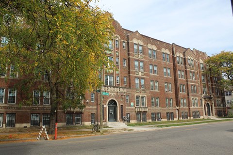 A large red brick building with a tree in front of it.