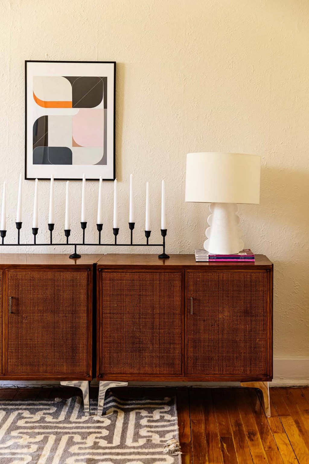A menorah sits on a cabinet next to a lamp.