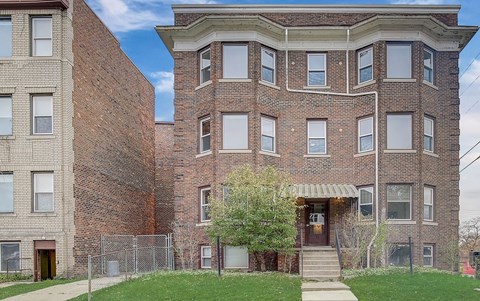 A brick building with a tree in front of it.