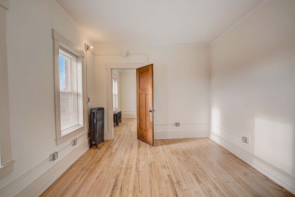 A room with a wooden floor and a door.