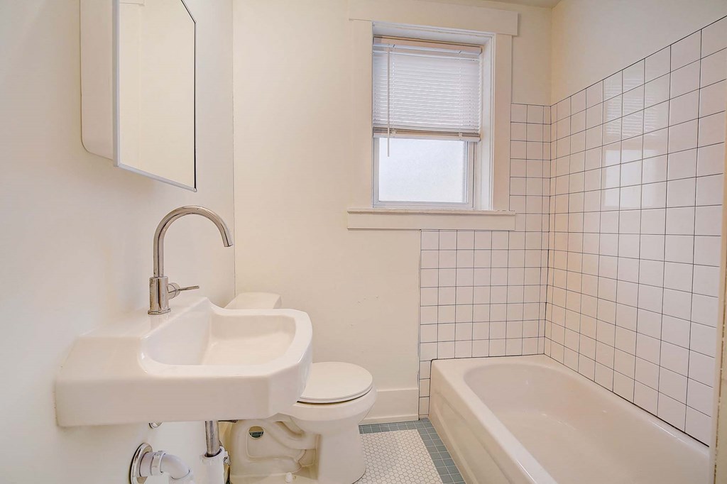 A white bathroom with a sink, toilet, and bathtub.