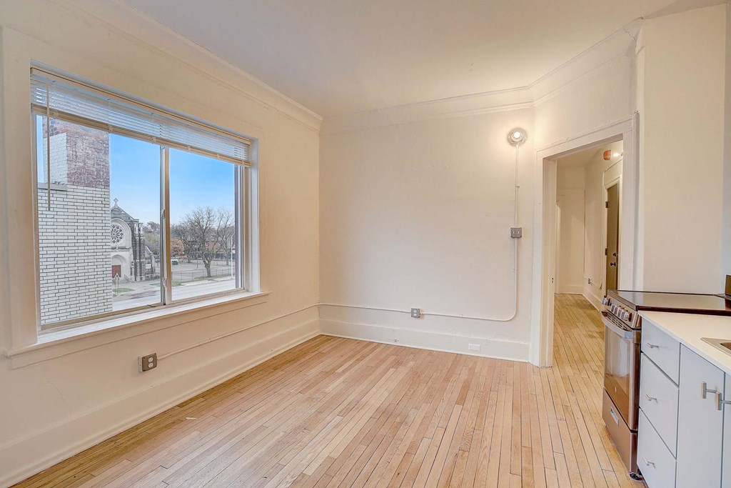 A room with a window and a kitchen area.