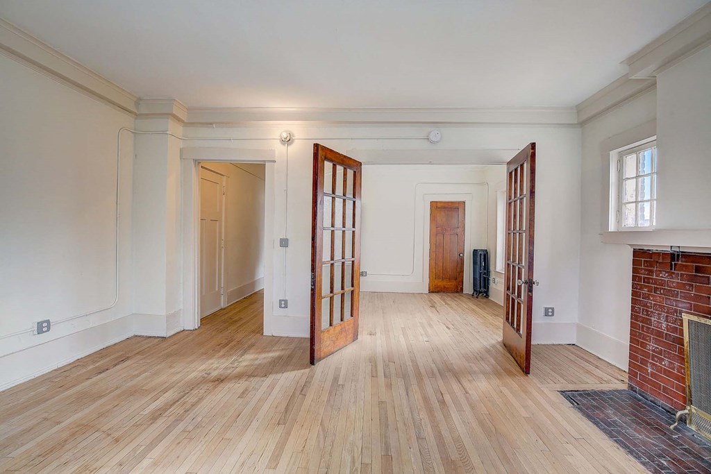 A room with wooden floors and a fireplace.