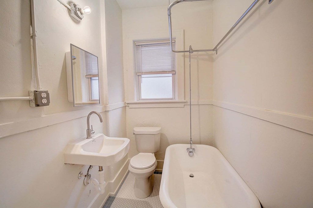 A white bathroom with a sink, toilet, and bathtub.