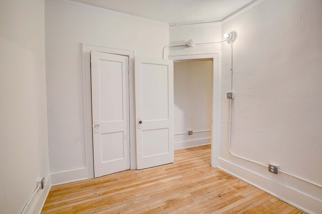 A room with two doors and a wooden floor.