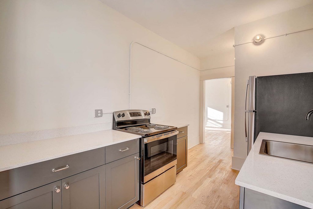 A modern kitchen with stainless steel appliances and wooden flooring.