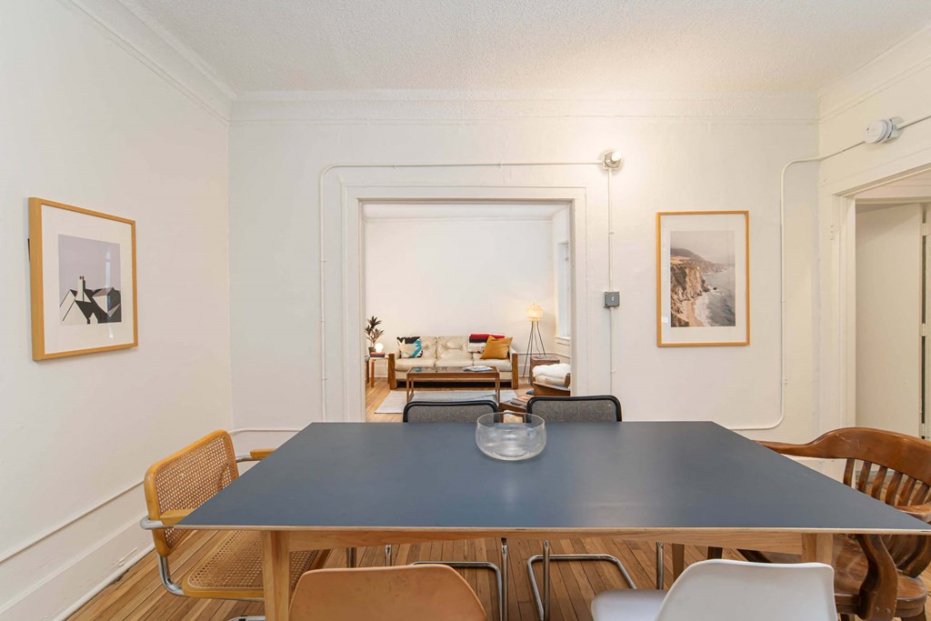 A dining room with a large table and chairs.
