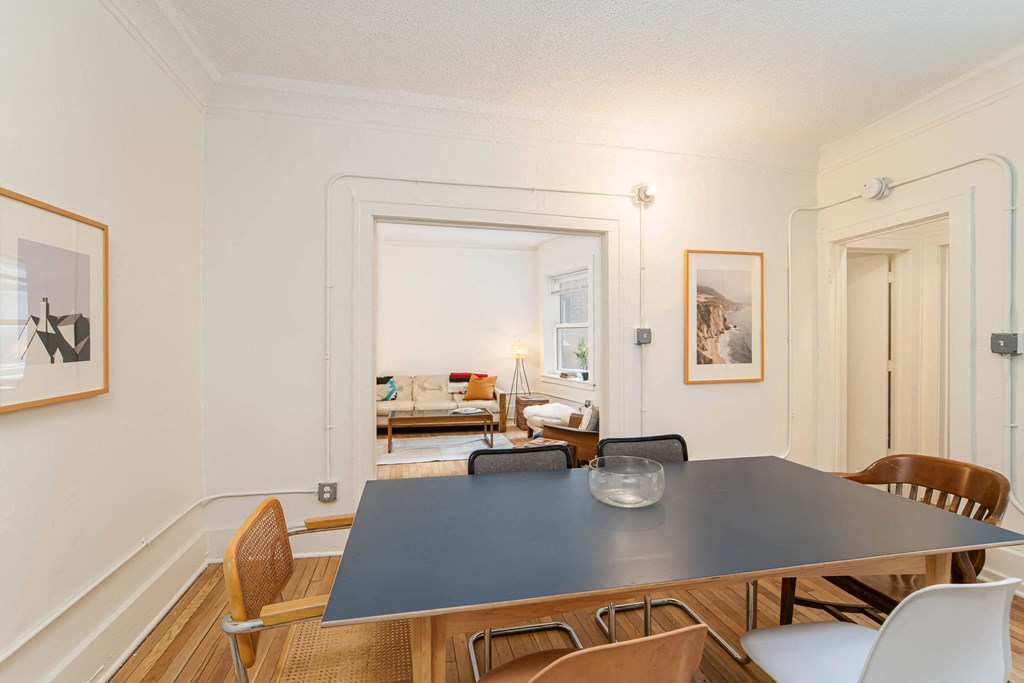 A dining room with a table and chairs.