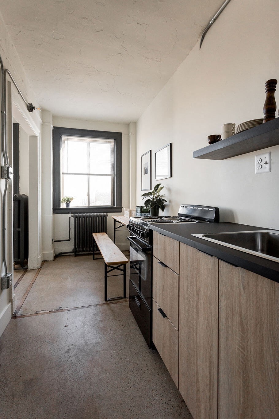 A kitchen with a black counter top and wooden cabinets.