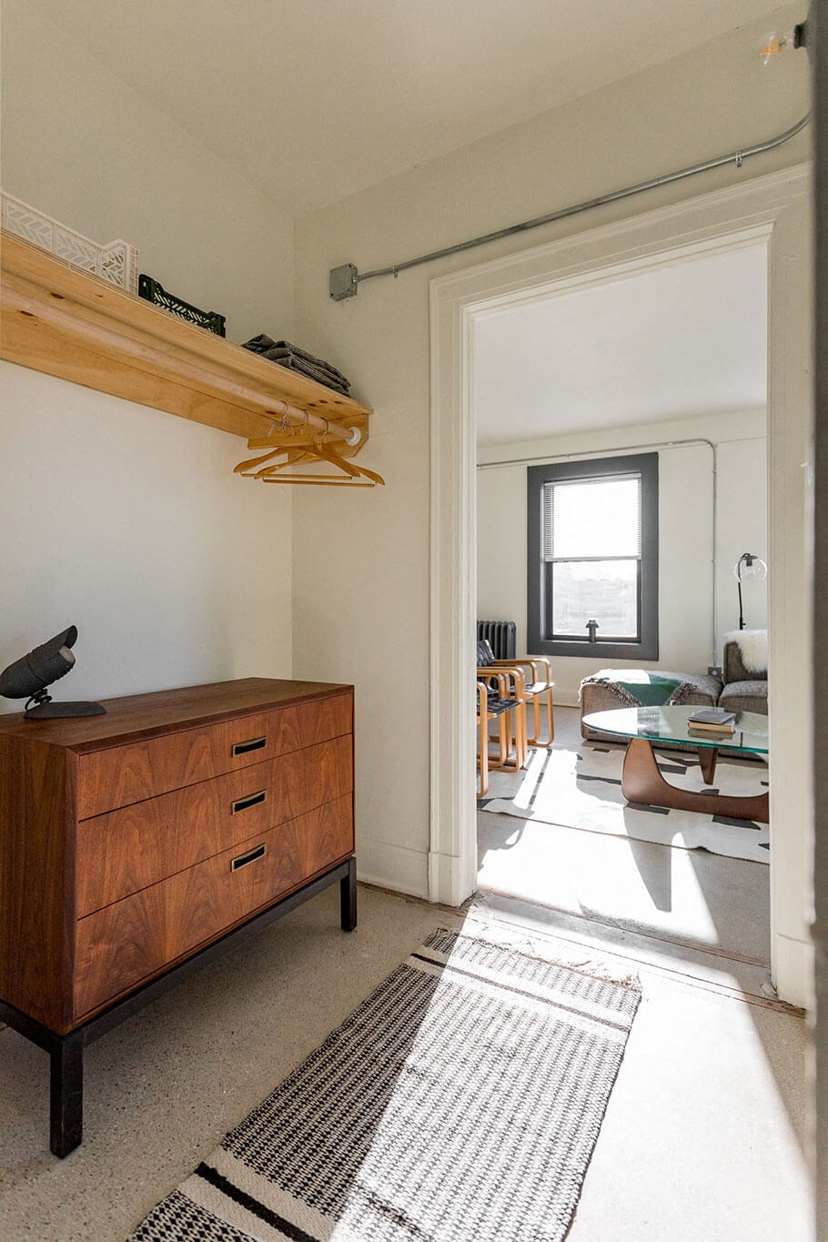 A room with a wooden dresser and a window.