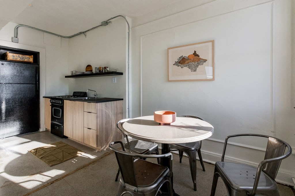 A kitchen with a table and chairs.
