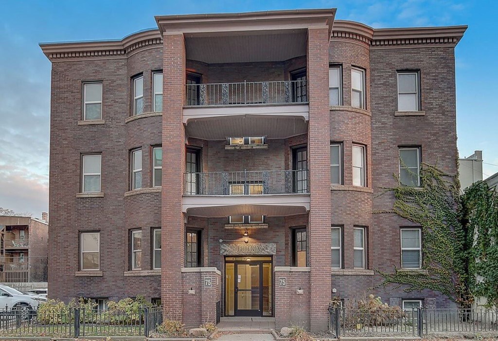 A red brick building with a balcony on the second floor.