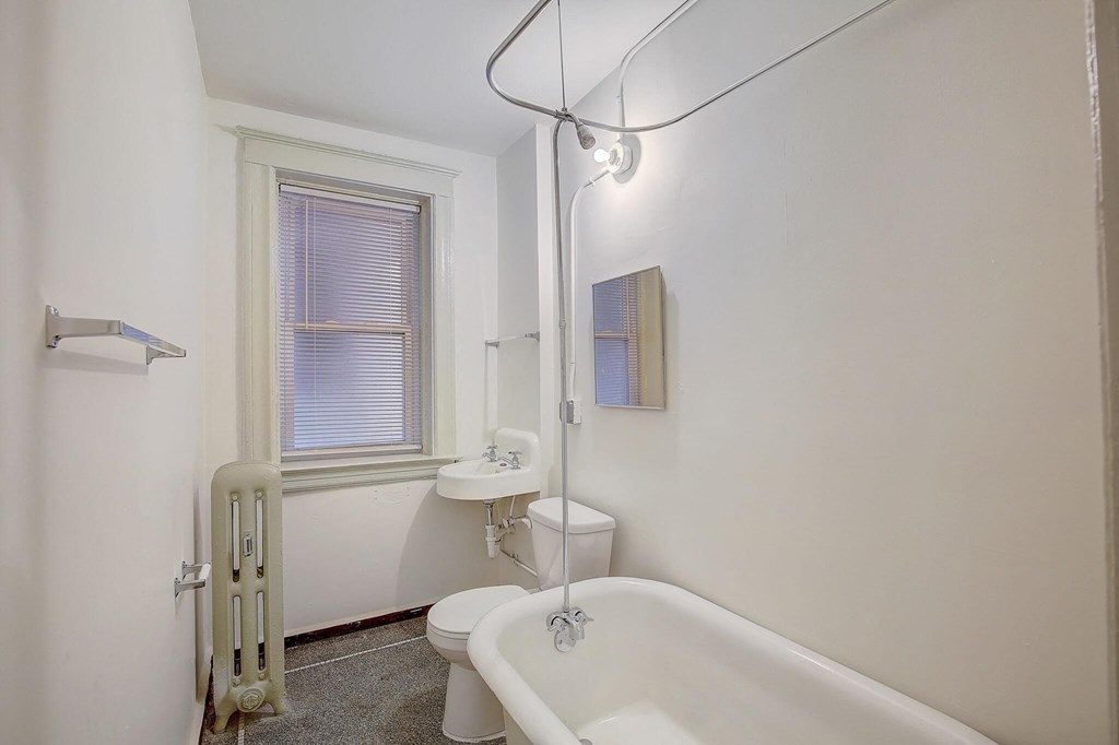 A white bathroom with a tub, toilet, and sink.