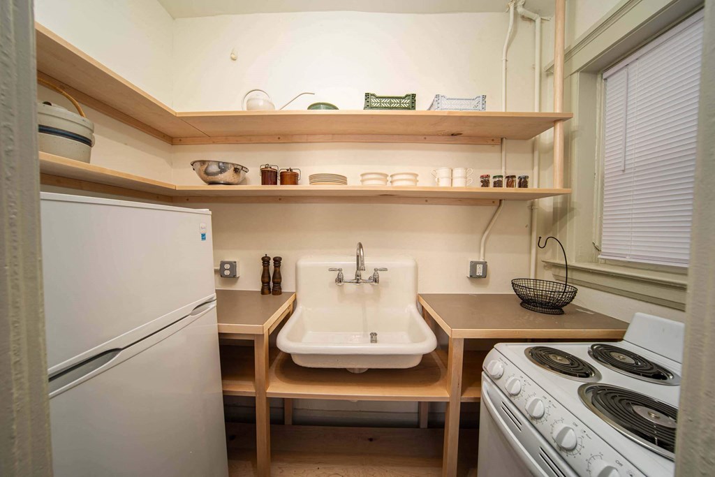 A small kitchen with a sink, stove, and refrigerator.