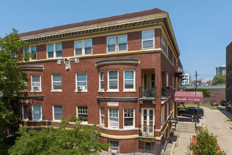 A red brick building with a balcony on the second floor.