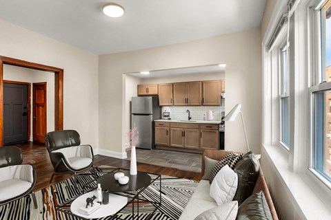 A modern living room with a black and white striped rug and a round table with a vase of flowers on it.