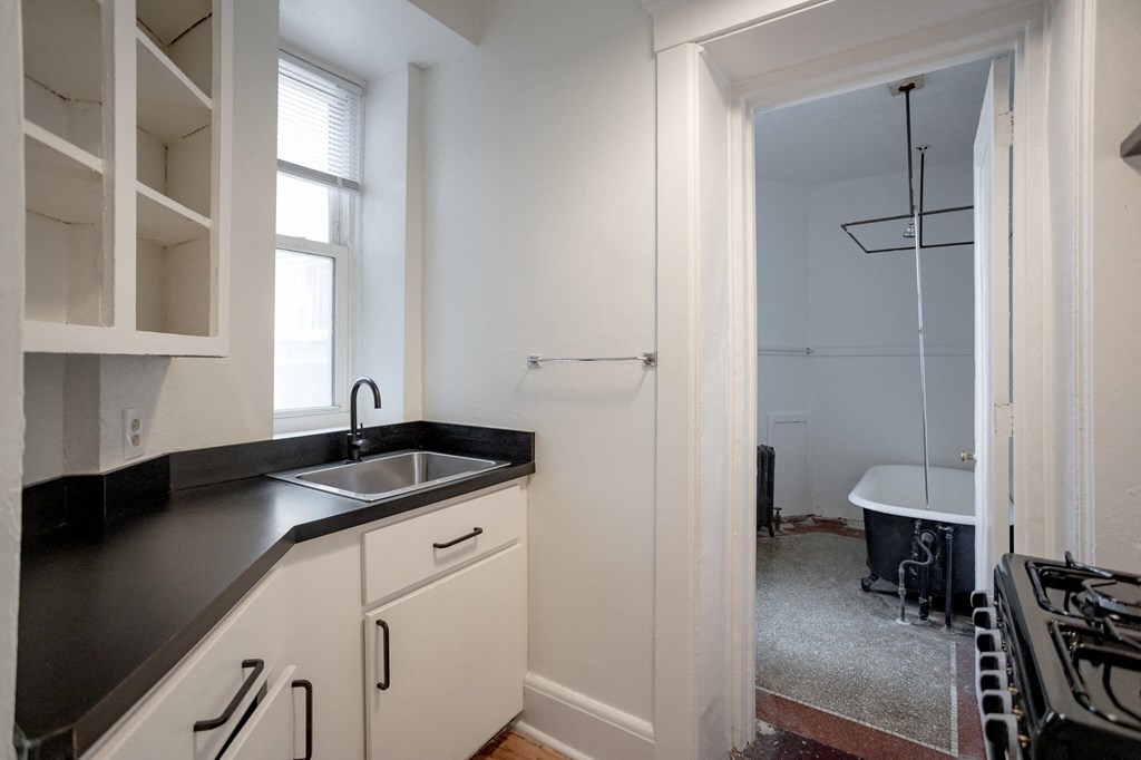 A kitchen with black countertops and white cabinets.