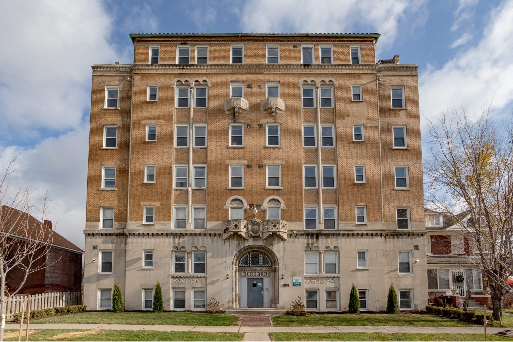 A large, two-story building with a balcony on the second floor.