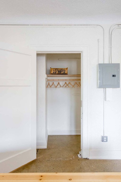 A white doorway leads to a room with a shelf and a box on the wall.