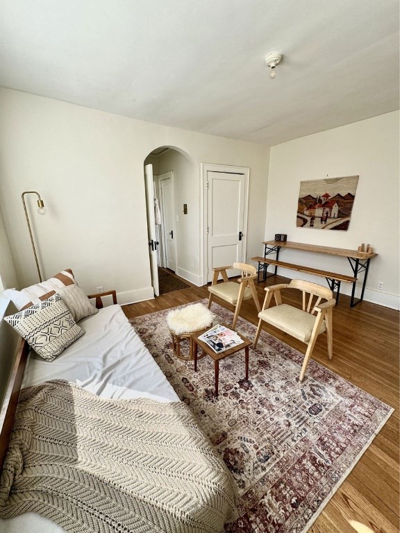 A bedroom with a bed, a chair, and a rug.