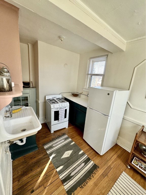 A kitchen with a white fridge and a white sink.