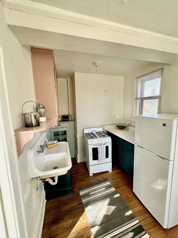A small kitchen with a white fridge and a sink.